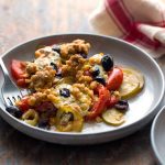 Tilt shift view of tomato and zucchini casserole with oats and cheddar